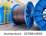 Small photo of Large diameter cable reels. Power cables on metal coil. Concept - production of electrical wires. Reel for installing power cable. Electric wires are kept outdoors. Power Wire Manufacturing