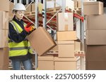 Small photo of Customs officer woman. Girl with boxes in bonded warehouse. Customs check of goods at International border. Customs officer with phone and scanner. Woman inspector in reflective vest with boxes
