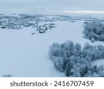 Aerial view of snow covered rural countryside in Switzerland, Europe. Trees and houses in winter time.