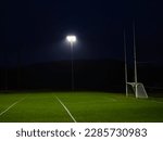 Small photo of Training ground with grass illuminated by modern powerful LED lights. Efficient modern technology. Nobody. Sport field with tall goal posts for rugby, camogie, hurling and Gaelic football. Irish sport