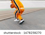 Hip hop dancer in trendy street clothes dancing on the stadium sports track. Street dancing concept. Stylish man dancing modern dance. Copy space. Hip hop background