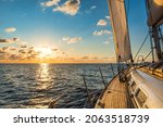Cruising sailboat sailing in the Mediterranean Sea at sunset