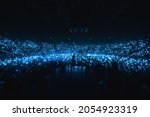 Vocalist in front of crowd on scene in stadium. Bright stage lighting, crowded dance floor. Phone lights at concert. Band blue silhouette crowd. People with cell phone lights.