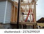 Small photo of Unrecognizable workers are intent on doing a good construction job with the addition of a new room on this home.