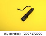 Small photo of black flashlight shocker on a yellow background.