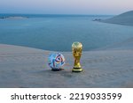 Small photo of Doha, Qatar - October 09, 2022: Replica FIFA Worldcup trophy with Al Rhila Official Match Ball in Inland Sea Qatar