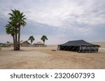 Small photo of Doha, Qatar - March 10, 2023: Bedouin tents at inland sea desert of Qatar