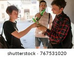 Small photo of Geek boy falls under bad influence. teenage alcohol addiction bad habits concept. Modern urban youth lifestyle