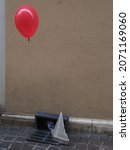Small photo of Ferrara, Italy - October 23, 2021. Halloween. Reproduction of the iconic scene from the movie It, the monstrous clown who hides in the sewers and lures children by showing them a balloon.