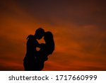 silhouette couple lover hugging in beauty sunset.