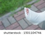 Small photo of Girl on crutches, leg in cast. patient holding wooden crutches isolated on blurred background. kid after misadventure , insurance concept. difficulties of movement. Copy space