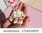 man Pouring capsules from a pill bottle ,holding pills on hand.Overdose of medication. A lot of pills spilled on table. Attempt of suicide.Economic crisis and medicine problems. Virus pandemic.
