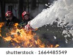 Firefighters extinguish a fire. Lifeguards with fire hoses in smoke and fire.