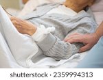 Small photo of Care for an elderly bedridden sick woman. The hand of a nurse strokes the hand of an elderly infirm woman.