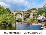 A view along the River Nidd towards the viaduct in the town of Knaresborough in Yorkshire, UK in summertime