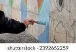 Male teenager hand painting a...