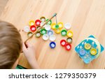 Small photo of boy learning to read. colorful bottle caps with syllables inside