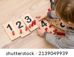 Small photo of Wooden figures of the Montessori methodology. Math kids counting puzzle for kids. Educational training in computing games to develop. An intelligent children's math toy. Number game board.