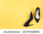 Stylish fashion black shoes high heels on yellow background. Flat lay, top view trendy background.