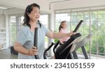 Small photo of Asian elderly women exercising on the machine in living room at home. Mature woman enjoy doing exercising on treadmill for well being slimming weight. Elderly lifestyle concept