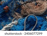 Small photo of Industrial Fishing Equipment Fishnets and Fishing Lines lying on concrete in the port, fishing industry