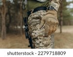 military hand. Camouflage tactical gloves.