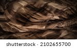 Small photo of brown-beige silk fabric, floral pattern, corrugation, reef, undulation, undulation, ripples, a small wave or a series of waves on the surface of the fabric