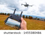 Landscaping on a quadcopter. A young man holds in his hand a quadcopter control panel with a monitor and an image of mountains
