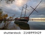 Small photo of The wreckage of La Grande Hermine, a relica carrack, lies abandoned and rotting in the water of Jordan Harbour near St. Catherines, Ontario during sunset.