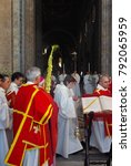 Small photo of ROME, ITALY 03/29/2015. Palm Sunday. Close up of Gospel of John. Clergymen pass the palm branch during the divine service in Papal Archibasilica of San Giovanni in Laterano, Rome. Selective focus.