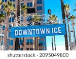 Small photo of Kristi Yamaguchi Downtown Ice sign advertises outdoor skating rink under palm trees - San Jose, California, USA - 2021