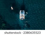 Small photo of Amazing top view of Catamaran anchored in blue sea in summer. Travel background. Cruise vacation.