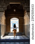 Small photo of Stunning view of a girl visiting the Bahia Palace during a sunny day. The Bahia Palace in Marrakech is an impressive example of Moroccan architecture and design.