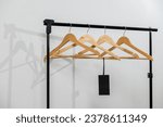 Row of empty hangers on the rack. Wooden coat hanger with blank tag against white background. Store concept. Advertising of Black Friday sales
