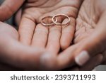 Gold rings in the hands, on the palms of the newlyweds. Wedding photography close up, macro.