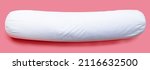Small photo of White bolster pillow on pink background.