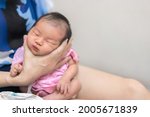 Small photo of Asian mother hold tiny newborn baby with hand for help infant belch after breastfeeding milk to heal gas pain or indigestion, Health care newborn at home.