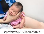 Small photo of Asian mother hold tiny newborn baby with hand for help infant belch after breastfeeding milk to heal gas pain or indigestion, Health care newborn at home.