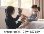 Small photo of Elder asian sister and younger Asian sister playing animal hand puppet doll toys, sitting on bed, Educational preschool games, Having fun with kid at home concept.
