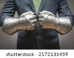 Businessman hands in the plate armor mittens close up. Help of a lawyer. Business protection concept.