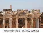 Small photo of Ancient antique amphitheater, columns on the stage of the amphitheater, steps and antique statues with columns in the amphitheater, Hierapolis in Pamukkale, Denizli City, Turkey.