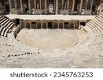 Small photo of Ancient antique amphitheater, columns on the stage of the amphitheater, steps and antique statues with columns in the amphitheater, Hierapolis in Pamukkale, Denizli City, Turkey.