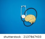 Small photo of A stethoscope and brain shape made from paper over a blue background. Awareness of Alzheimer's, Parkinson's disease, dementia, stroke, seizure, or mental health. Neurology and Psychology care
