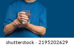 Small photo of Close-up of hands senior woman trying to hold a glass of water. Causes of hand shaking include Parkinson's disease, stroke, or brain injury. Mental health neurological disorder