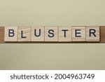 Small photo of gray word bluster made of wooden square letters on brown background