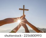 Small photo of Silhouette family hands praying and holding Christian cross for worshipping God on mountain at sunrise background. Christian, Christianity, Religion copy space background. Easter Sunday concept: