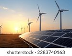 solar power plant with wind turbines at sunset under a blue sky 
