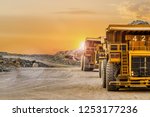 Large Yellow Dump Trucks transporting Platinum ore for processing