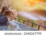 Small photo of The hand of a young man praying to God for the power of God to fulfill the request of the Christian faith. The young man prayed to God for blessings based on his faith and power of faith in Him.