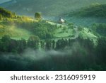 Church from Apuseni Mountains, Romania in a beautiful morning a little bit of fog with the sunlight touching the hills